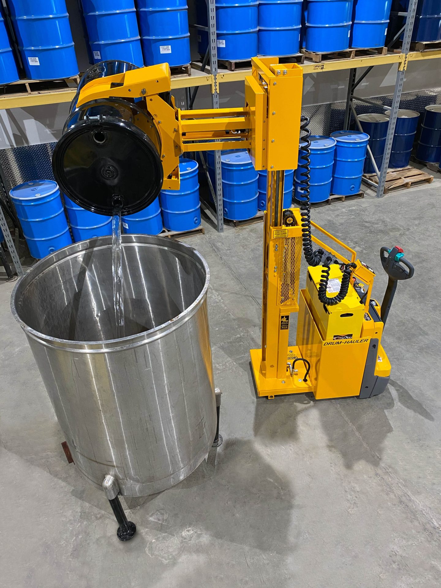 03-Drum-Hauler-with-1324-8-Ext.-Reach-Clamp-dumping-drum-into-tank-min